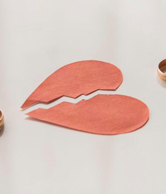 Małżonkowie zdejmują obrączki, na stole leży obrazek złamanego serca, co symbolizuje separację małżeńską, która może prowadzić do rozwodu