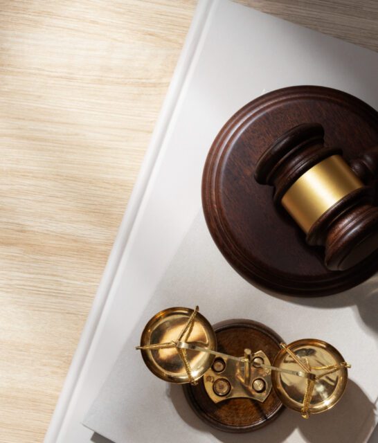 Młotek sędziowski oraz waga symbole prawa na kartkach papieru, przestawiające zmiany w prawie w 2024 roku